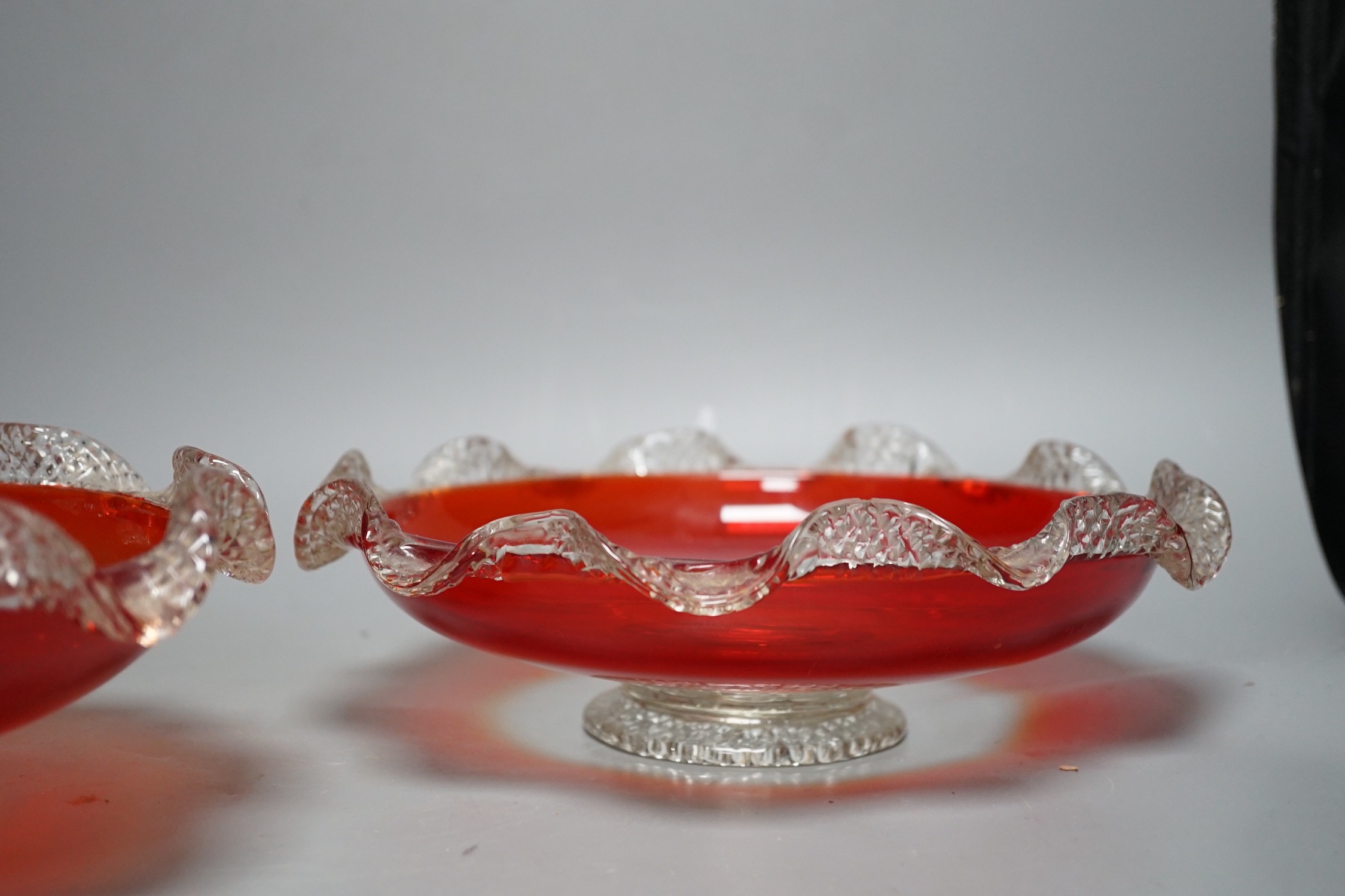 A pair of early 20th century ‘fancy’ glass dishes with inset coins to base, 29cm diameter